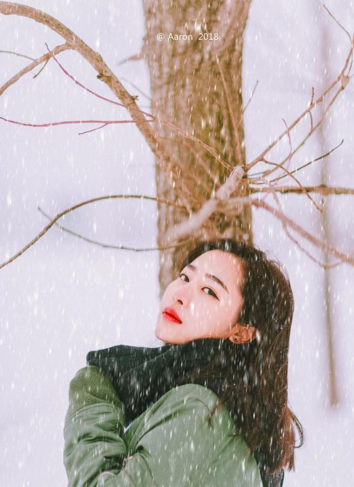 满天飞雪的冬季,女孩的围巾和头发也被吹动