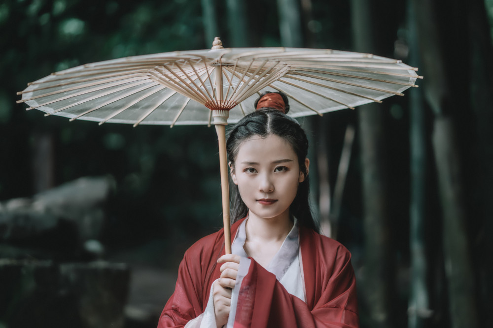 美女红衣古装照,置身竹林撑伞吹箫别有一番风味