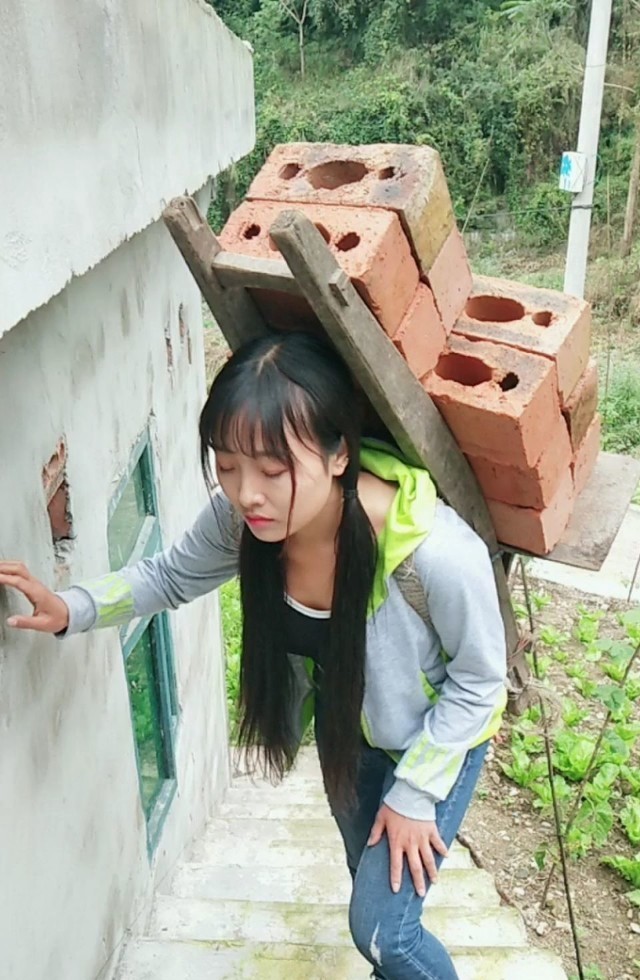 彝族姑娘解古阿星搬砖中,与其他人不同,十足的女汉子.