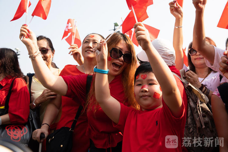 市民们手拿小国旗,脸上身上贴满旗帜,多位小朋友也穿着红装兴高采烈