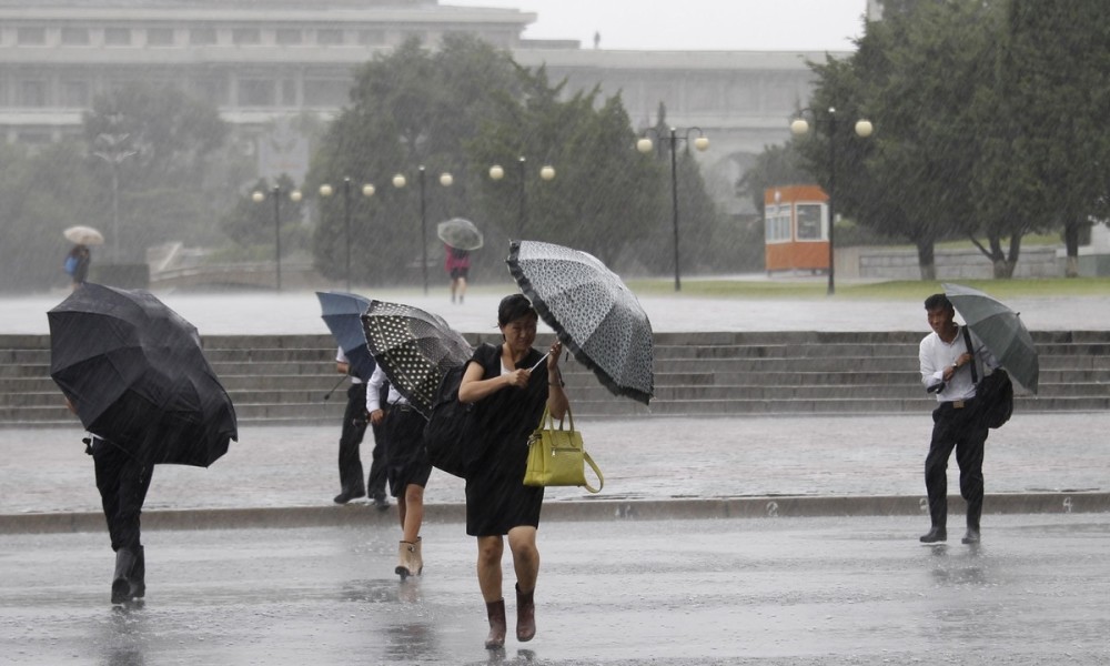 台风"玲玲"登陆朝鲜带来强风暴雨 民众撑伞出行全身湿透