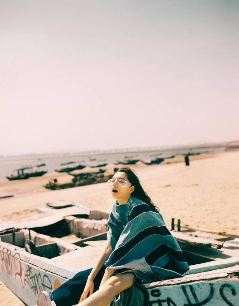 闭眼吹着海风,海滩边的美丽女生