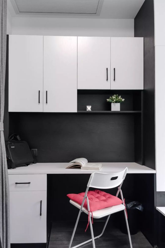 次卧深灰色的木地板,搭配黑白配的定制书桌,衣柜 榻榻米床,简洁优雅而