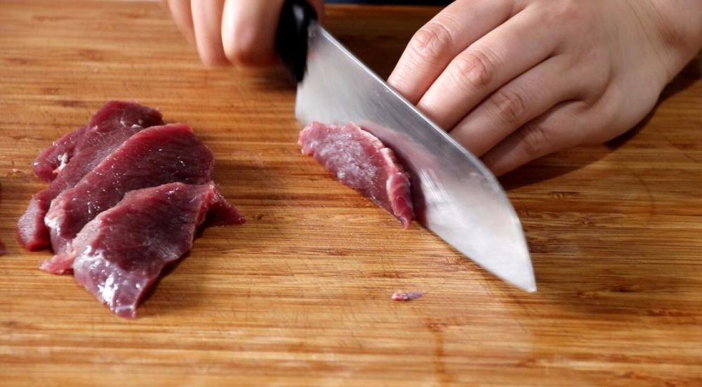 牛肉洗净,逆着纹路切片,随后再改刀切成丝儿.