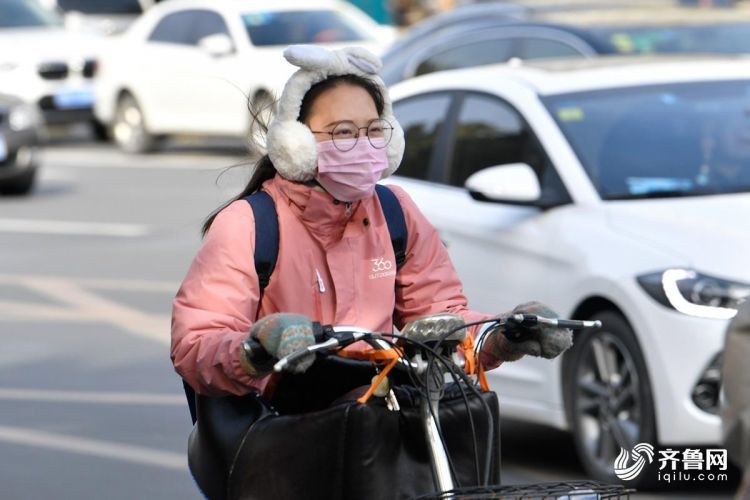 骑电瓶车出行的市民,穿戴上各种保暖"装备".