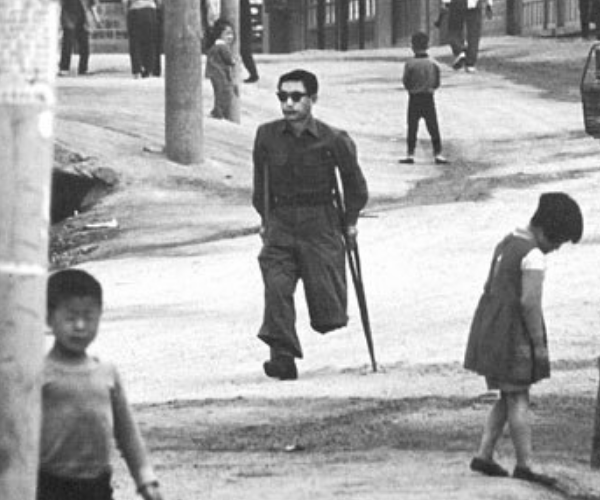 图为在战争中被炸断一条腿的朝鲜人民,战争使他永远的变成了残疾人.