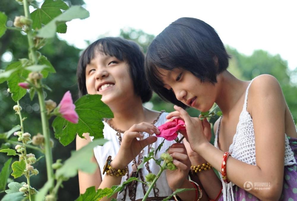 姐妹俩在焦作市人民公园的游玩时,一起用手抚摸花朵,感受美好.