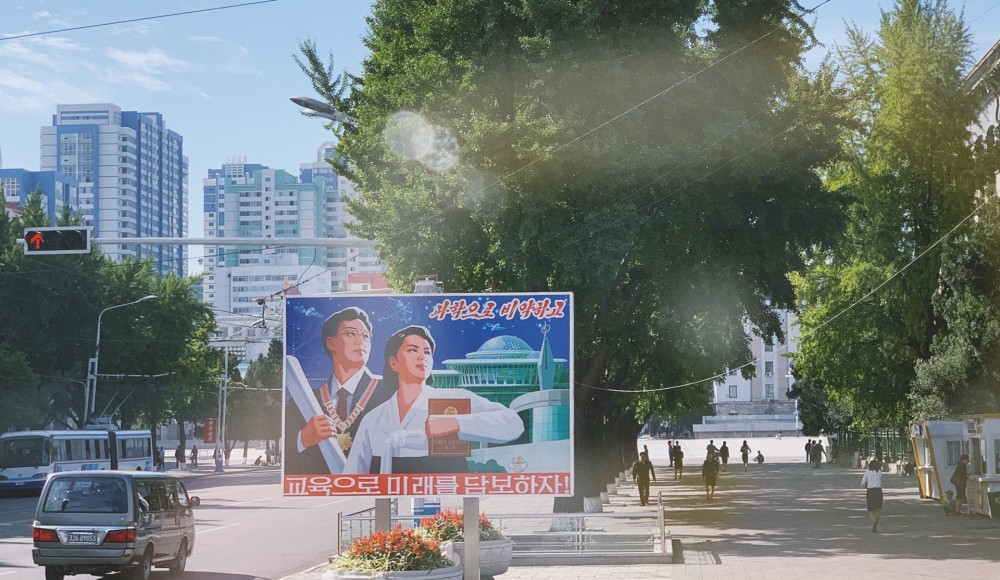 图为朝鲜平壤的街景,街头能见到步行的路人和宣传画.