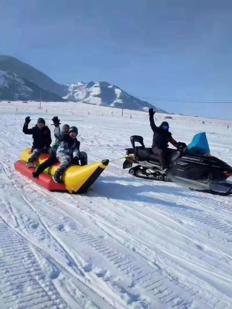 一只巨大香蕉船滑行在洁白的冰雪上, 乘坐者体验着心跳加快的感觉