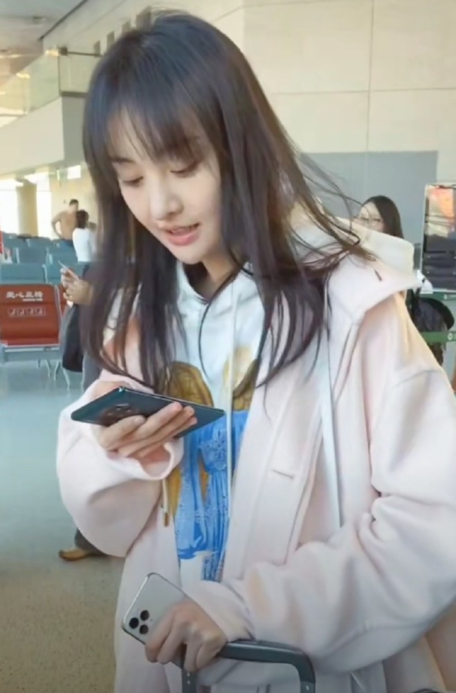 郑爽机场素颜被拍:左手一个苹果iphone,右手一个华为