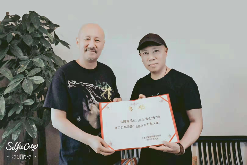 廖哥为腾格尔颁发聘书 北京的磁器口大街,是一片热闹的市中心商业区.