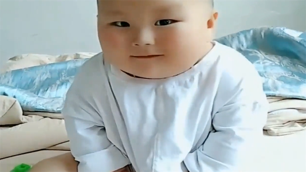 萌娃研究自己肚子上的肉肉,发现妈妈在偷拍后,脸上的表情太搞笑