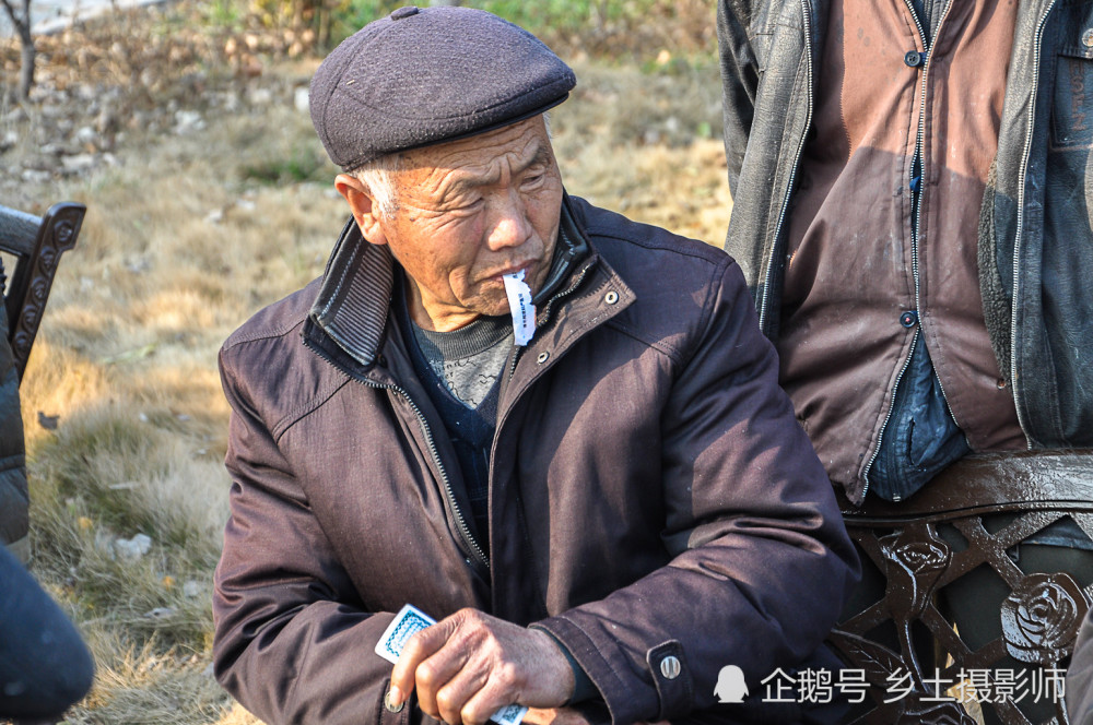 皖北老人冬季打扑克娱乐,输牌的农村老头脸上贴纸条,充满浓浓乡情