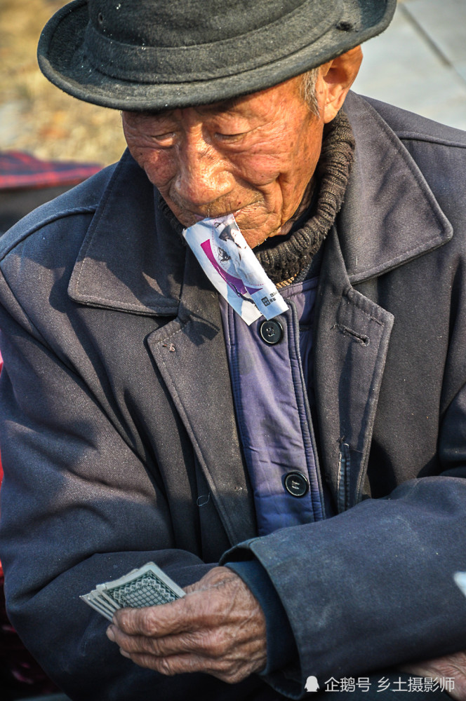 皖北老人冬季打扑克娱乐,输牌的农村老头脸上贴纸条,充满浓浓乡情