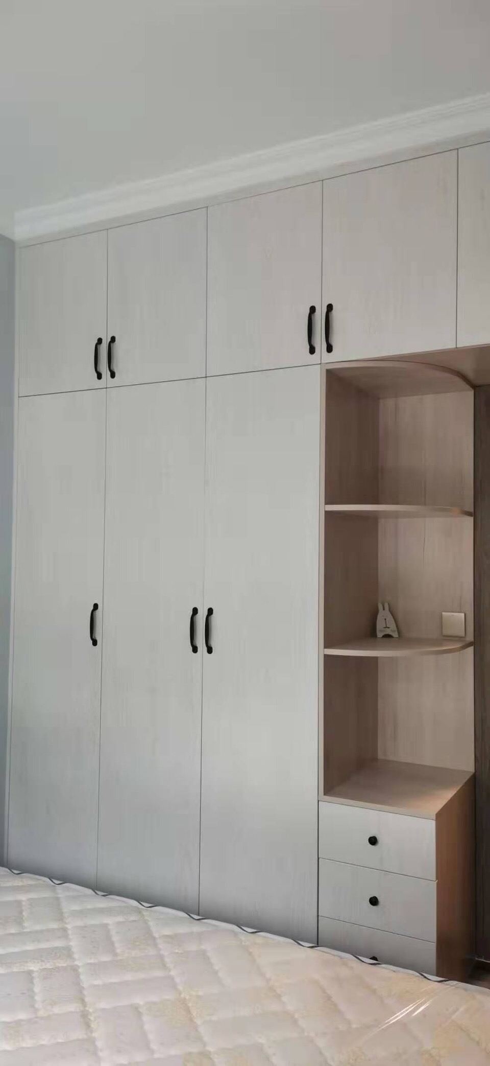 定制的衣柜分为两种颜色,其中柜体是原木色,加上白色的柜门,显得很