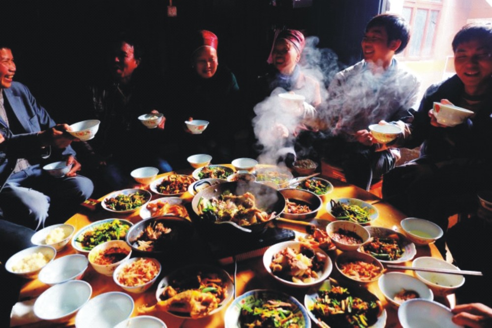 新年围坐在一起吃饭的乡亲