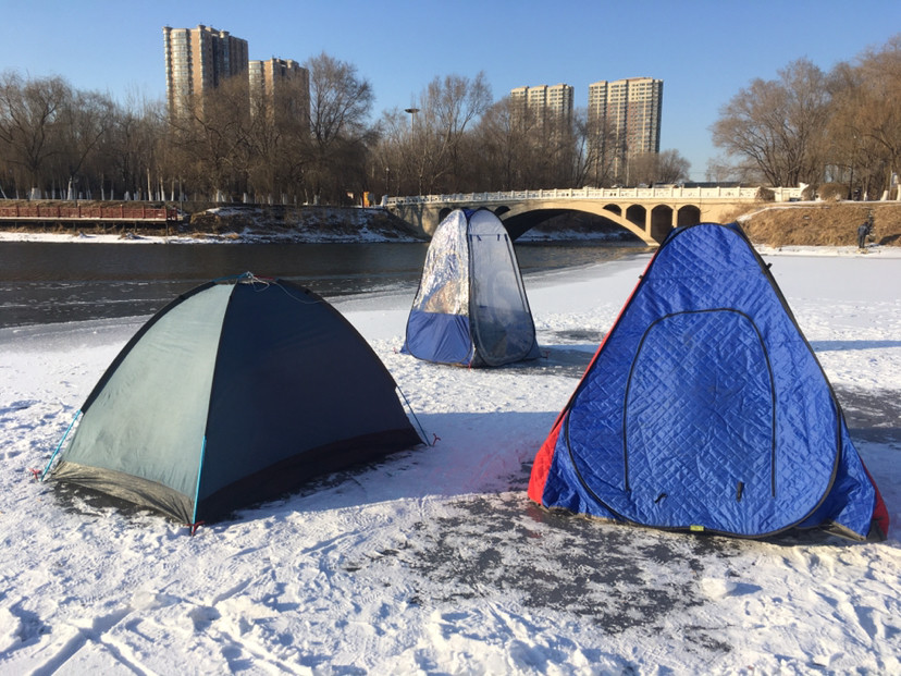 仔细一看是市民在冰面上支起帐篷进行冬季冰雪休闲娱乐