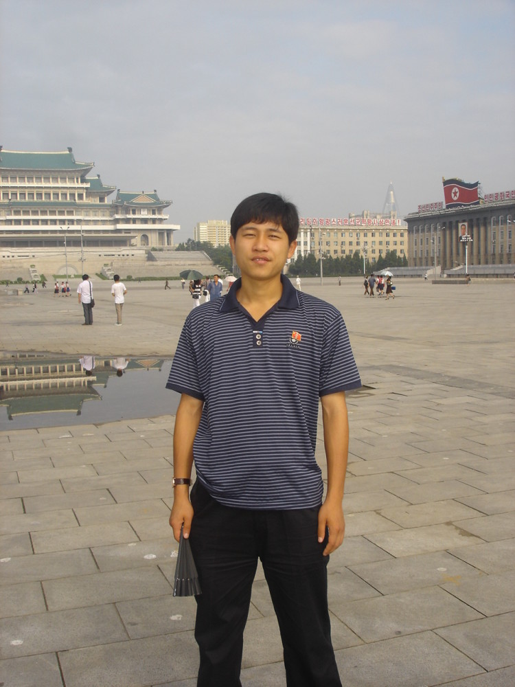 图为朝鲜平壤的一个广场上,一名朝鲜男导游在拍照.