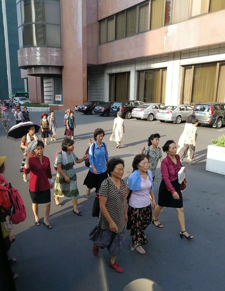 图为朝鲜平壤大街上来往的路人,人们都行色匆匆.