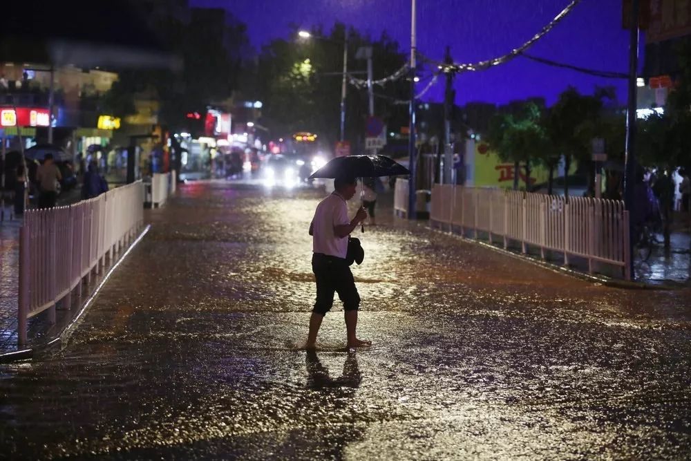 2015年5月6日,广州市员村二横路,雨中趟水过马路的男士. 作者简介