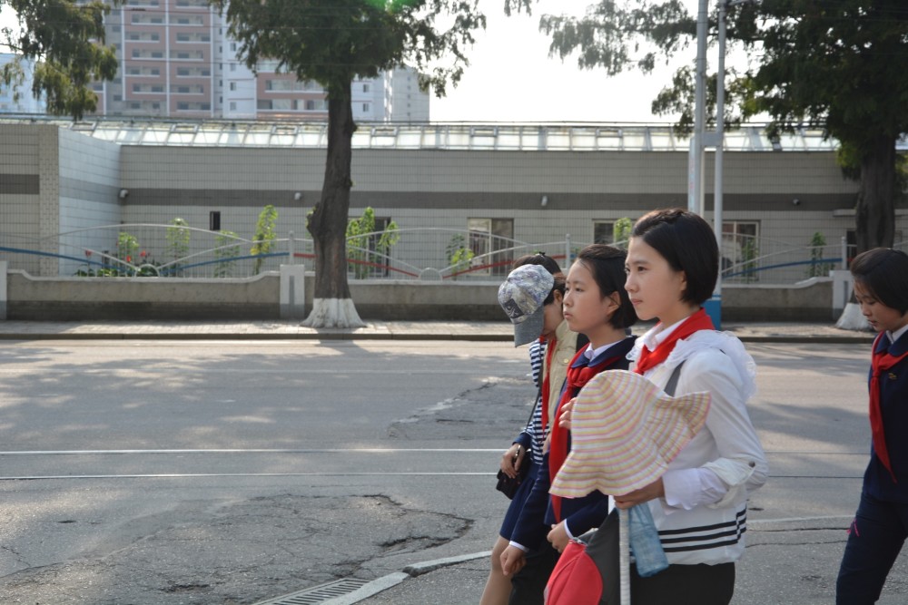 图为朝鲜街头三名并肩行走的女学生,她们看起来天真可爱.