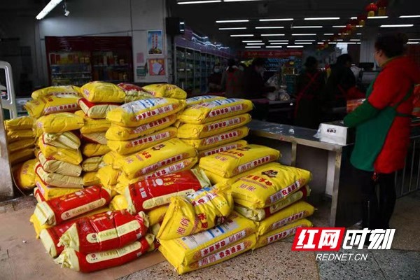 在新邵县城一家大型超市内,工作人员忙着将一批新到的大米摆放在靠近
