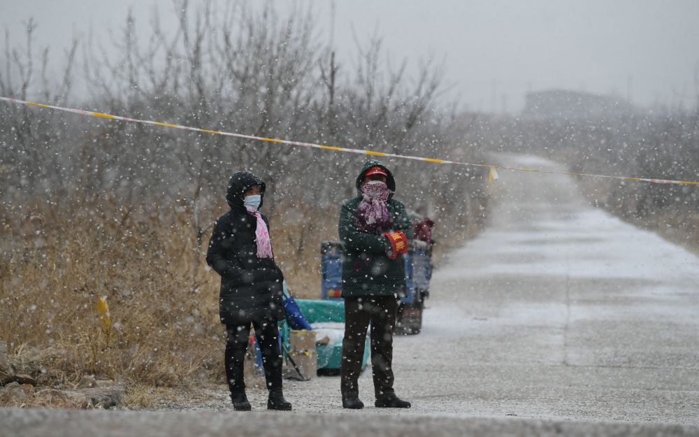 大雪中,乡村路口的防疫员们