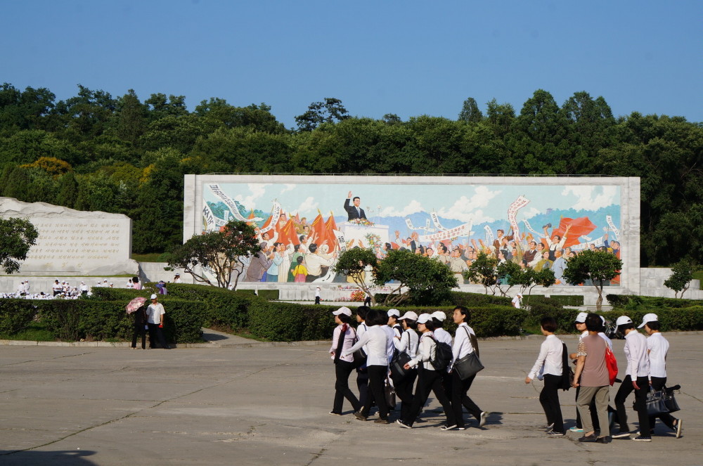 图为朝鲜街头,一群朝鲜女生穿着黑色长裤,白色衬衫集体出游.