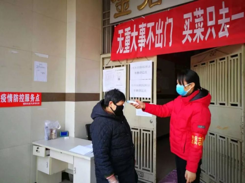 叶永红同志正在对进入小区的人员进行体温检测,解读政策知识,进行疫情