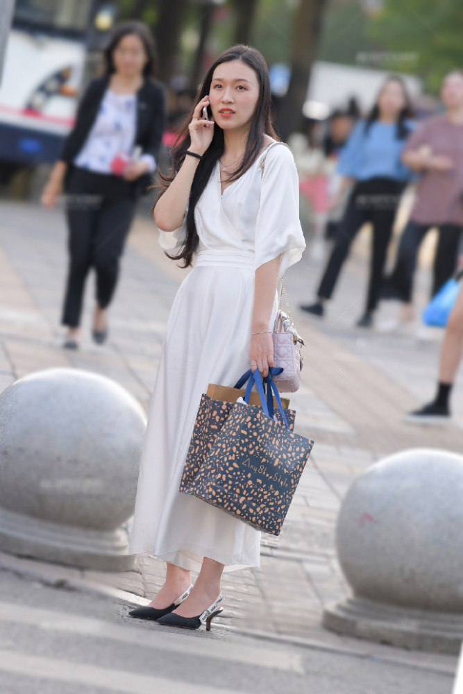 街拍时尚穿搭,站在路口身穿白色连衣裙的美女