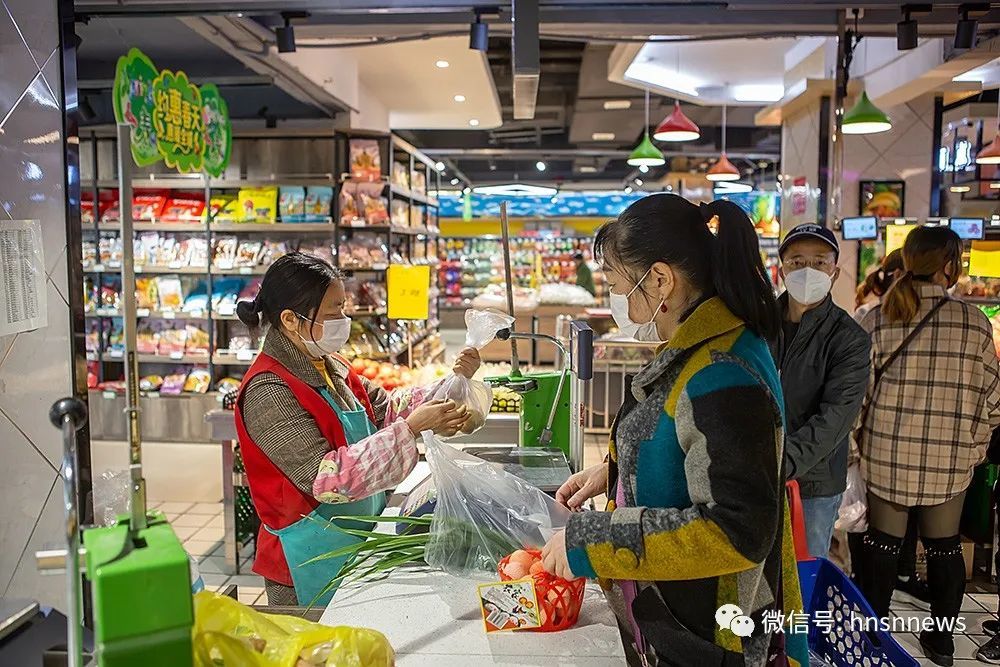 县城一超市工作人员在给市民称物品打价