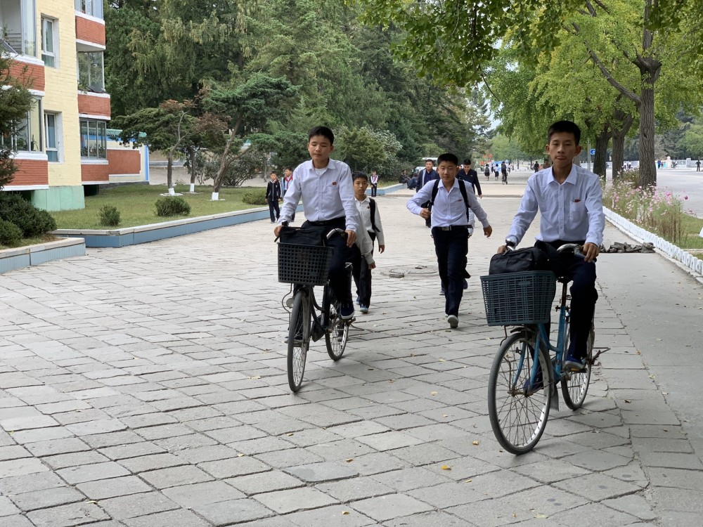 图为朝鲜开城街头骑自行车的学生,朝鲜学生上学放学都喜欢骑自行车.