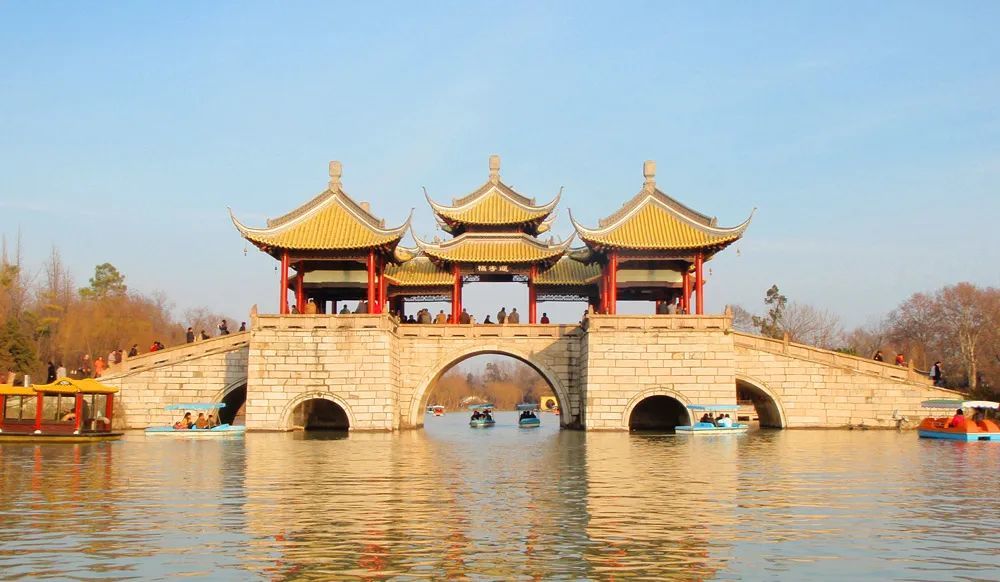 扇形中的图案则是扬州市的地标建筑之一的 五亭桥轮廓剪影.