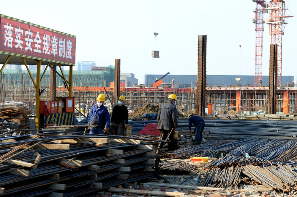 3月5日,肥东县一学校建设项目的施工人员在工地上作业.