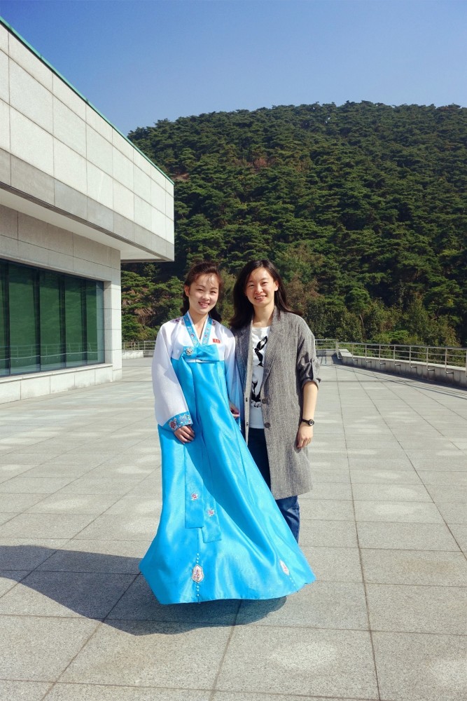 图为朝鲜某景区,一名女游客和一名女导游,女导游长得很美.