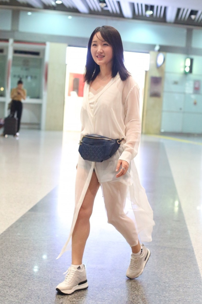 杨钰莹春光满面独自机场,穿白色防晒衣走路带风,48岁满满少女感