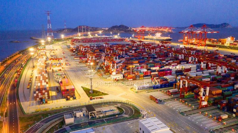 2020年3月20日,上海洋山港自动化码头停泊着多艘超大型集装箱船,卡车