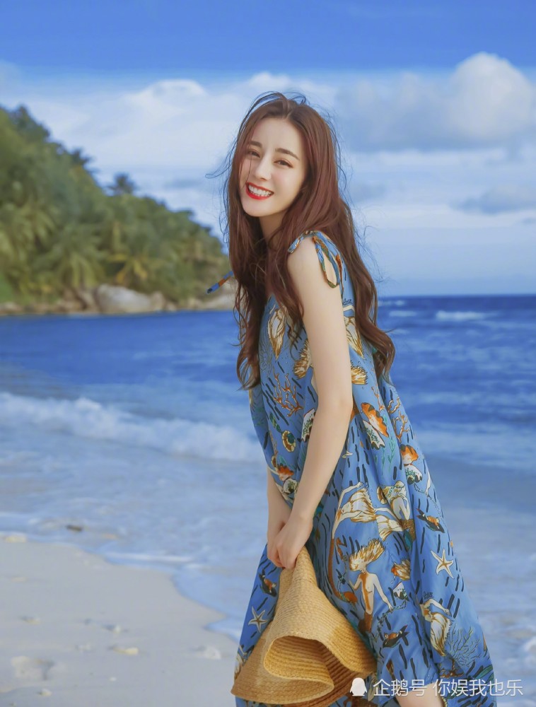 迪丽热巴海边度假美照,春夏气息十足的橘色系妆容,搭配蓝色系印花裙超