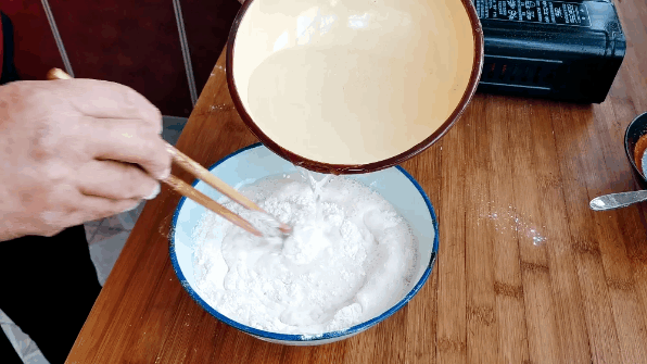 5:锅中烧水,水开倒入拌好的面粉水,边倒边搅拌(一定要慢慢倒入,否则