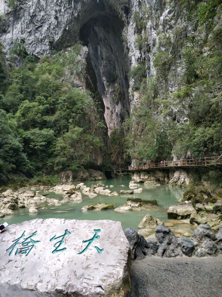 横跨河两岸的天然巨岩,是天生桥,高60米,厚10米,桥孔宽2o多米,河水流