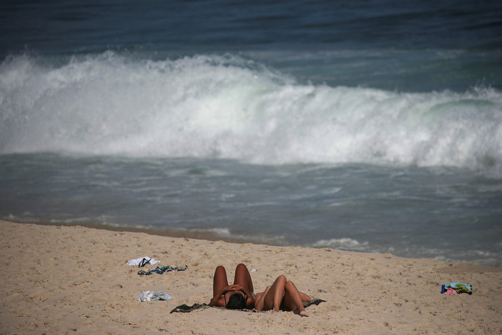 巴西海滩风大浪高 游客悠闲晒日光浴 日出时分悠闲跑步冲浪