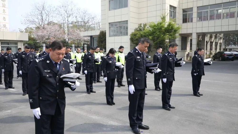 鸣响 汽车停驶鸣笛 行人停步肃立 民警将警帽摘下托在手上 低头默哀
