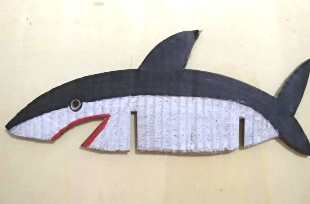 在纸板上画出鲨鱼的身体并涂好颜色剪下来.