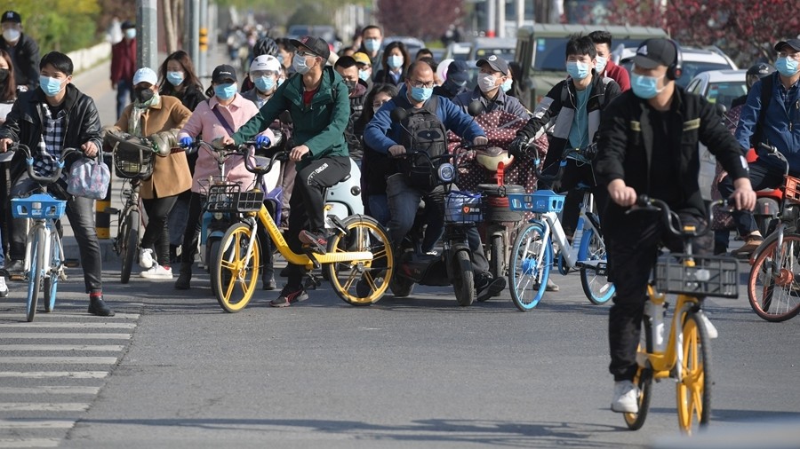 北京:疫情期间市民戴口罩骑行上班