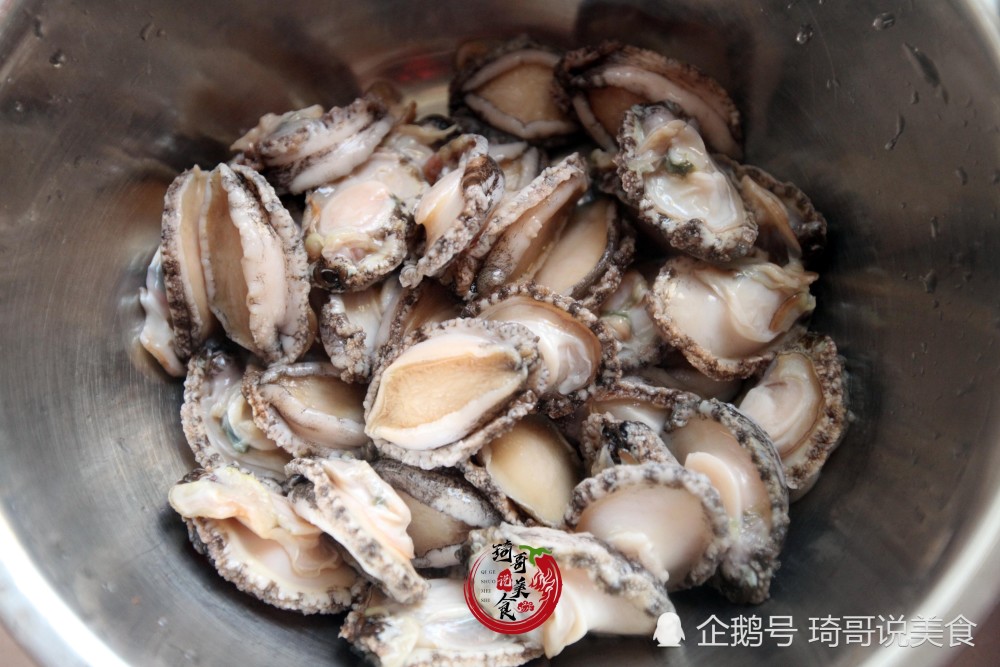 步骤二:用勺子挖出鲍鱼肉,摘去鲍鱼的内脏和牙齿,洗净备用.