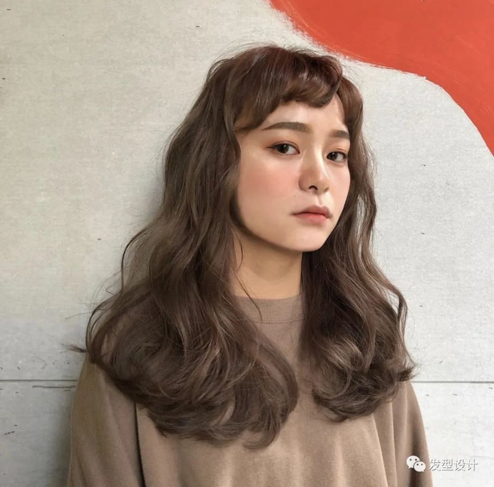 对于圆脸的妹子来说, 也是非适合的一款侧分中长卷发发型, 齐发尾发型