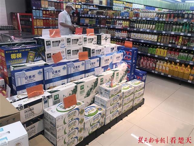 13日,在武昌东亭一家超市,记者看到,多个品牌的牛奶被摆在促销货架上