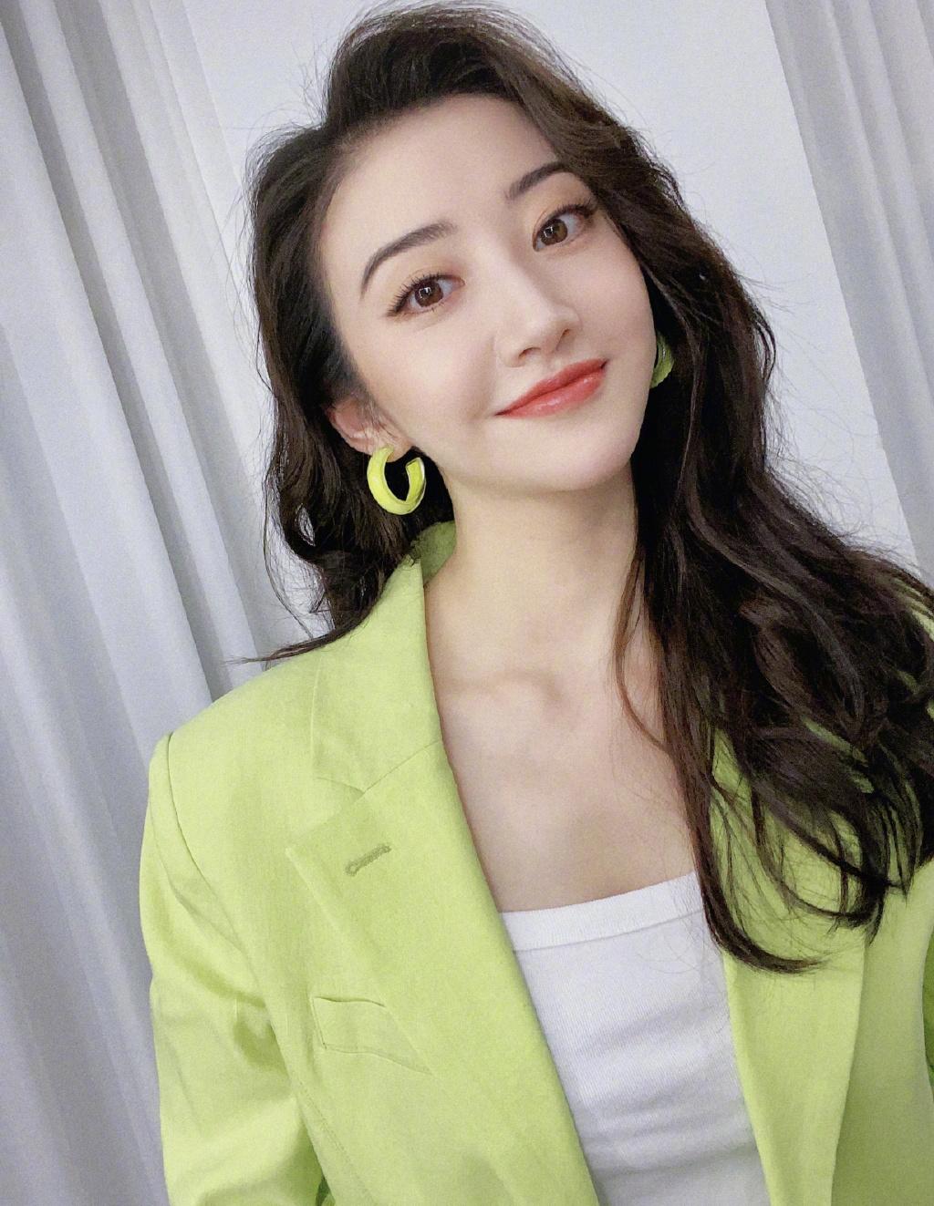 这个拍照角度本身就显得她的五官明艳精致,再加上撩发的动作,更是性感