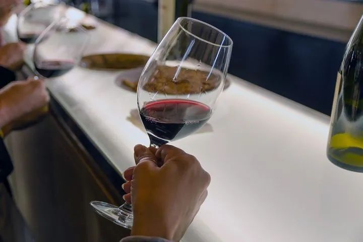 正确的拿红酒杯手势 1,持杯时可以用食指和中指夹住杯角,喝时可以拿