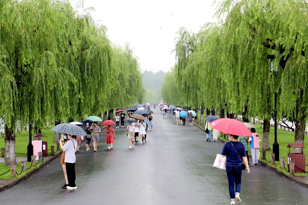 浙江杭州,梅雨季节的杭州继续下着雨,游客雨中欣赏杭州西湖美景,别样